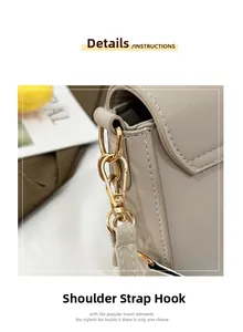 Close-up of beige faux leather bag with detailed gold metal shoulder strap hardware
