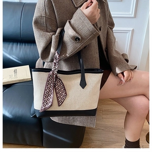 Borsa tote in tela con finiture in pelle nera e foulard di seta marrone sul divano