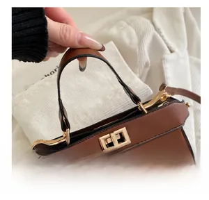 Detailaufnahme der braunen Ledertasche mit goldener Schließe und feinen Nähten