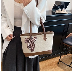 Dettaglio della borsa tote in tela con finiture in ecopelle marrone e foulard di seta decorato