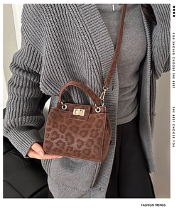 Detail of leopard print faux suede bag featuring a metallic turn-lock and sturdy handle