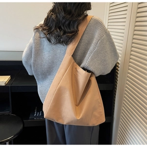 Grand sac cabas en daim kaki porté à l'épaule pour montrer la taille et l'effet réel