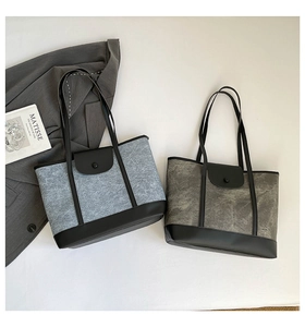 Détail de sacs fourre-tout en feutre gris et cuir noir avec de longues bandoulières