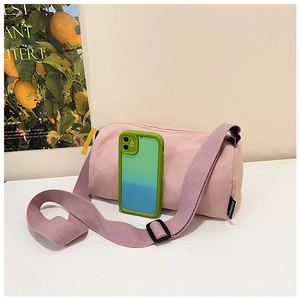 Pink nylon crossbody bag next to a mobile phone case showing compact portable size