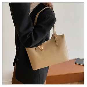 Detail view of khaki leather tote bag featuring golden triangle hardware on shoulder strap