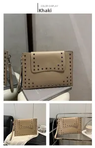 Detail of khaki rivet envelope clutch featuring square metal studs and smooth stitching