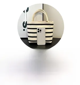 Vue détaillée du mini sac rayé en toile avec poignées en corde et référence de taille mobile