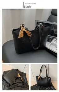 Detail of black tote bag with white contrast stitching and geometric silk scarf handle