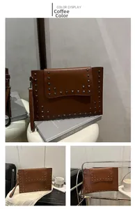 Macro detail of brown leather envelope clutch with silver square metal rivet studs