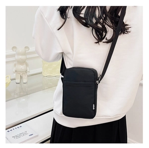 Rear view of a minimalist black nylon crossbody phone bag with adjustable strap and Sport tag