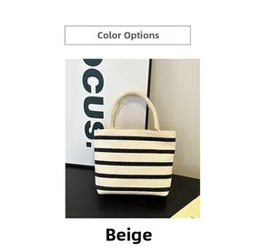 Détail du sac à main en toile à rayures beige et noir montrant la texture et les anses
