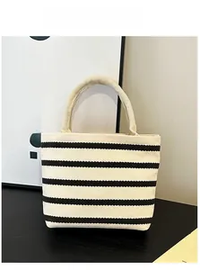 Vue verticale d'un sac à main minimaliste en toile avec des rayures horizontales noires et blanches