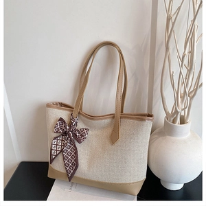 Dettaglio della borsa tote in tela con finiture in pelle e fiocco decorativo in seta