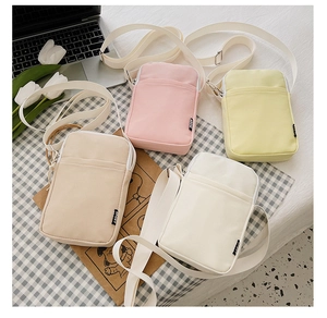 Detailed view of canvas crossbody bags in pastel colors with adjustable sport straps