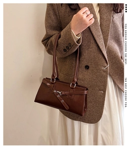 Detail of vintage dark brown glossy leather shoulder bag with silver buckle and belt strap