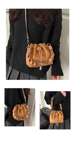 Detail of brown faux suede bucket bag featuring woven handle and drawstring closure