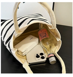 Détail du sac fourre-tout en toile rayée montrant l'espace pour téléphone et batterie