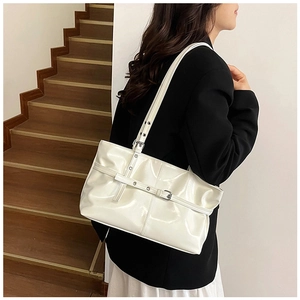 Détail de la boucle métallique réglable et texture simili cuir blanc brillant du sac