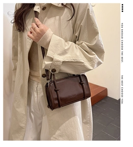 Detail view of fashion letter embossing on dark brown leather square shoulder bag