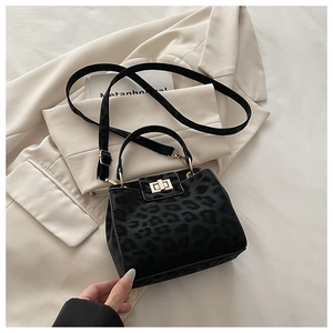 Détail du sac léopard en suédine avec fermoir rotatif doré et poignée chic