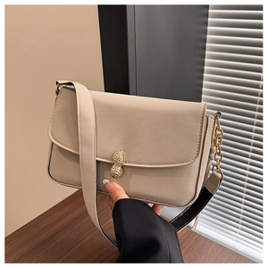 Detail view of cream white PU leather shoulder bag with unique golden peanut metal clasp
