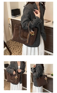 Close-up of vintage dark brown suede tote bag with fringe and cute bear charm detail