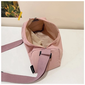 Top view detail of pink nylon crossbody bag showing spacious interior and strap