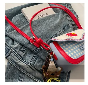 Close-up of the metal buckle on a blue plaid crossbody bag with adjustable shoulder strap