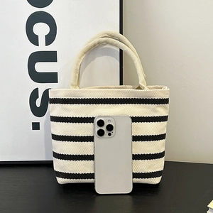 Mini sac cabas en toile à rayures noires et blanches pour femmes posé sur une table