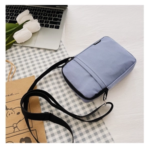Close-up of blue nylon crossbody bag with textured fabric and adjustable strap