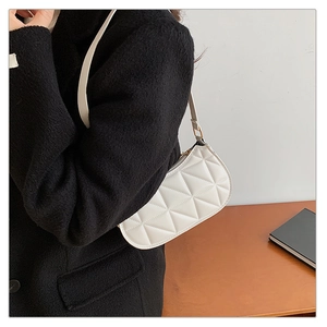 Gros plan sur le sac croissant blanc matelassé avec fermeture éclair dorée et bandoulière