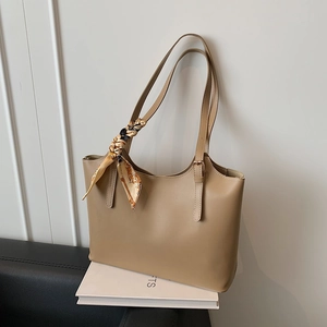 Minimalist khaki tote bag with silk scarf detail on a leather shoulder strap