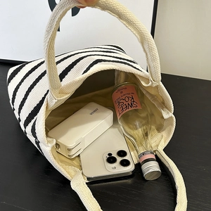 Sac à main en toile rayé noir et blanc montrant l'intérieur spacieux et les articles