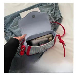 Internal capacity of plaid shoulder bag showing smartphone, wallet and cosmetics inside