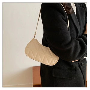 Gros plan du sac à bandoulière matelassé crème avec motifs géométriques élégants