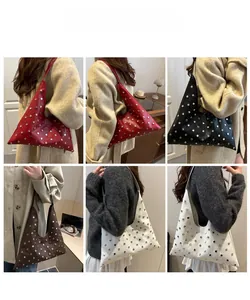 Vue détaillée des sacs à rivets déclinés en rouge, noir, marron et blanc