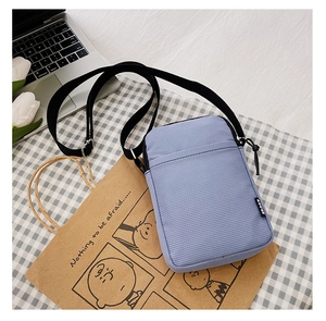 Detailed close-up of light purple nylon phone bag with adjustable crossbody strap