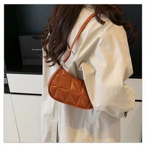 Gros plan du sac hobo orange-brun avec matelassage géométrique 3D et texture cuir brillante