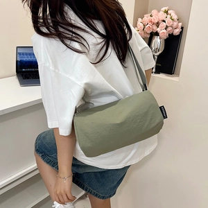 Minimalist green nylon crossbody bag with adjustable wide strap and compact square design