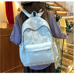 Detail of light blue galaxy print backpack with moon and stars patterns on nylon fabric