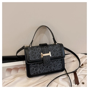 Detail of vintage square handbag with GK monogram pattern and gold metal buckle