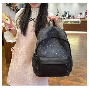 Detail of a large capacity black backpack with white star and moon prints