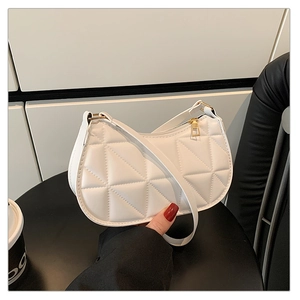 Vue détaillée de la texture en cuir matelassé blanc et de la fermeture éclair dorée du sac