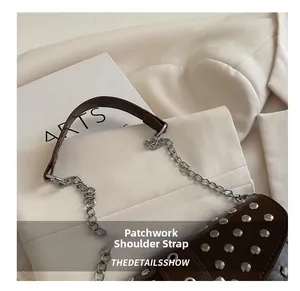 Detail of studded leather shoulder strap combined with silver metal chain for stylish bag