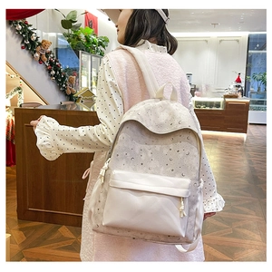 Detail of printed light beige backpack with stars and moon patterns and side pockets