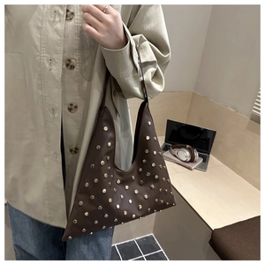 Gros plan sur un sac vintage en cuir marron orné de rivets dorés pour le quotidien