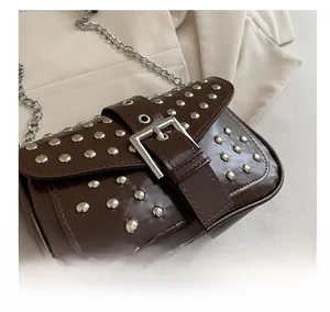 Close-up of vintage brown PU leather bag with silver metal rivets and chunky buckle detail