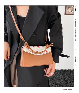 Detail of printed envelope bag with heart pattern and adjustable shoulder strap