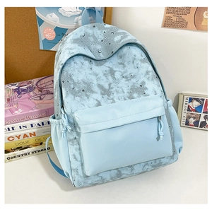 Close-up of light blue tie-dye backpack with moon and star patterns and side pockets