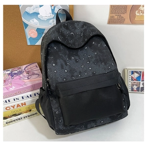 Detail of printed starry sky backpack with silver moon and star patterns on black canvas